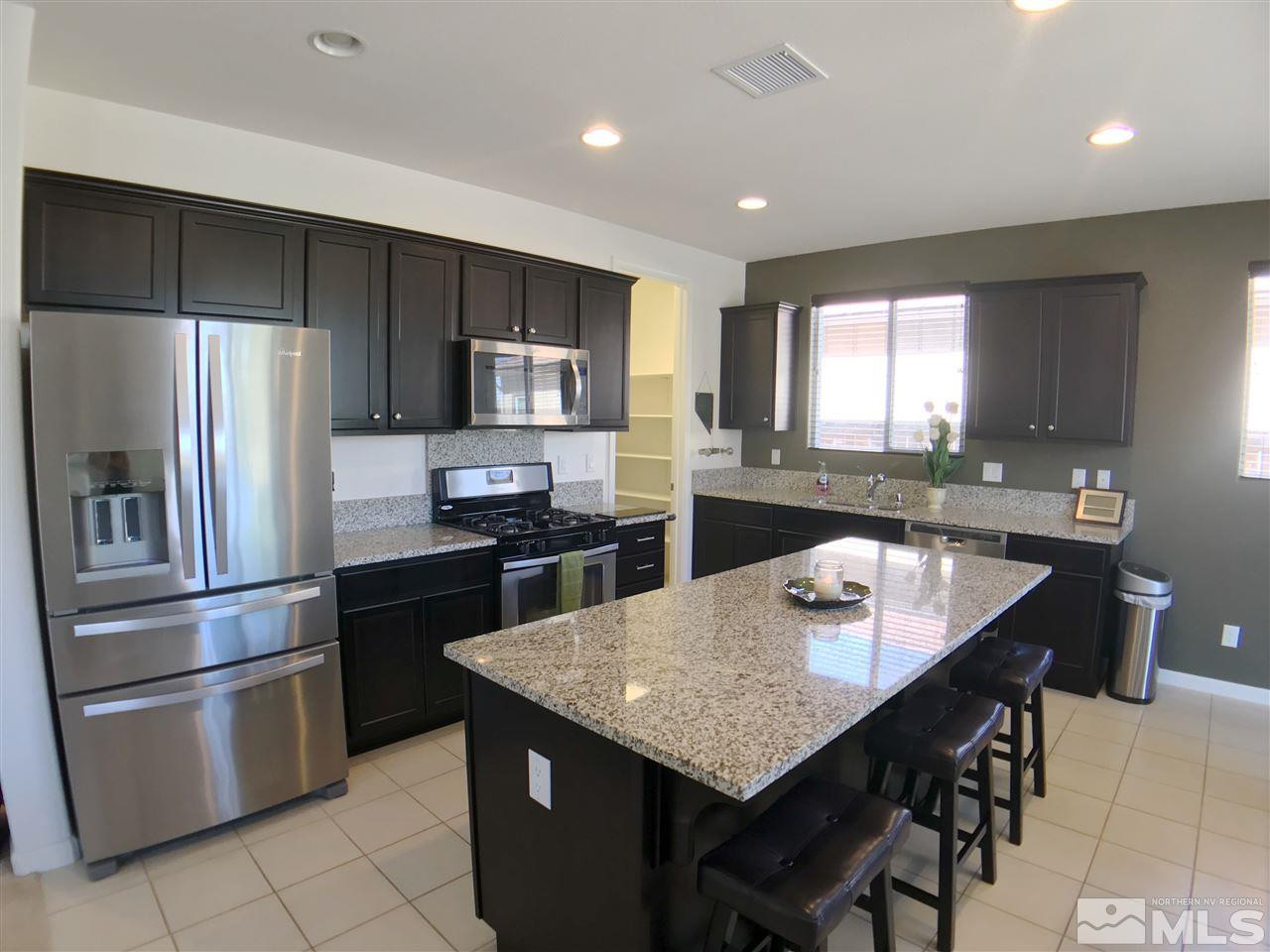 2935 Show Jumper Lane Reno, NV 89521 - Photo 3 of 19 a kitchen with stainless steel appliances granite countertop a sink a stove a refrigerator and a refrigerator