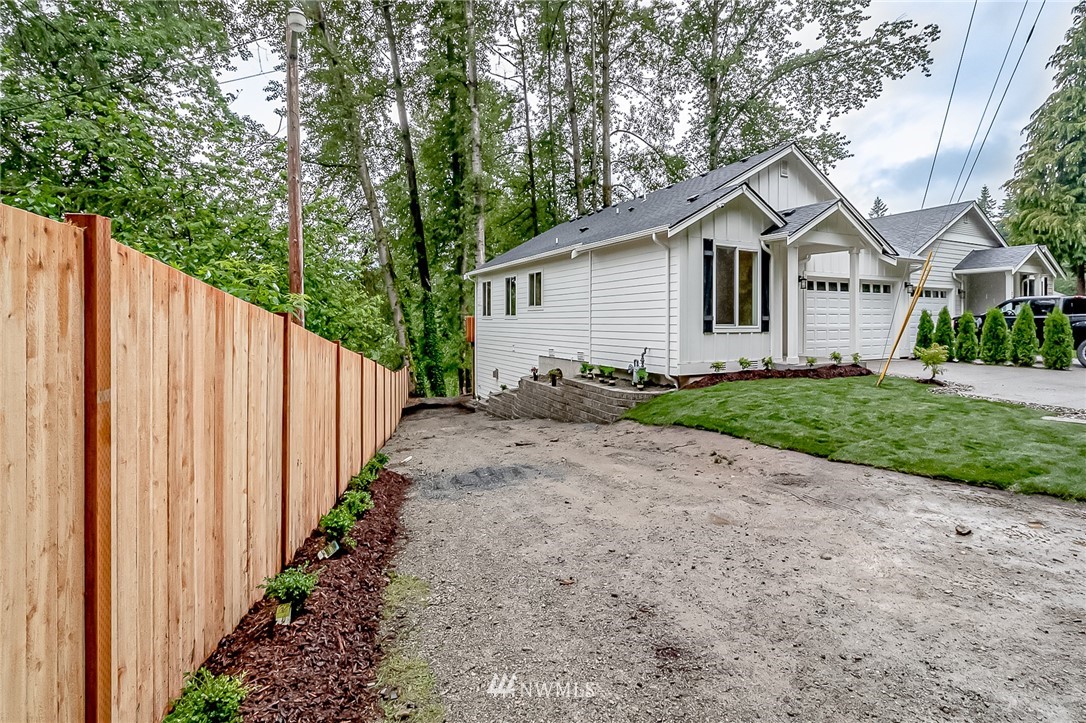 2624 Callow Road, Unit A Lake Stevens, WA 98258 - Photo 2 of 22 a view of a white house with a small yard and large trees