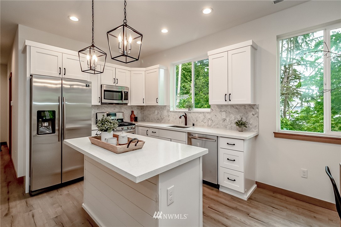 2624 Callow Road, Unit A Lake Stevens, WA 98258 - Photo 10 of 22 a kitchen with kitchen island granite countertop a sink cabinets stainless steel appliances and a large window
