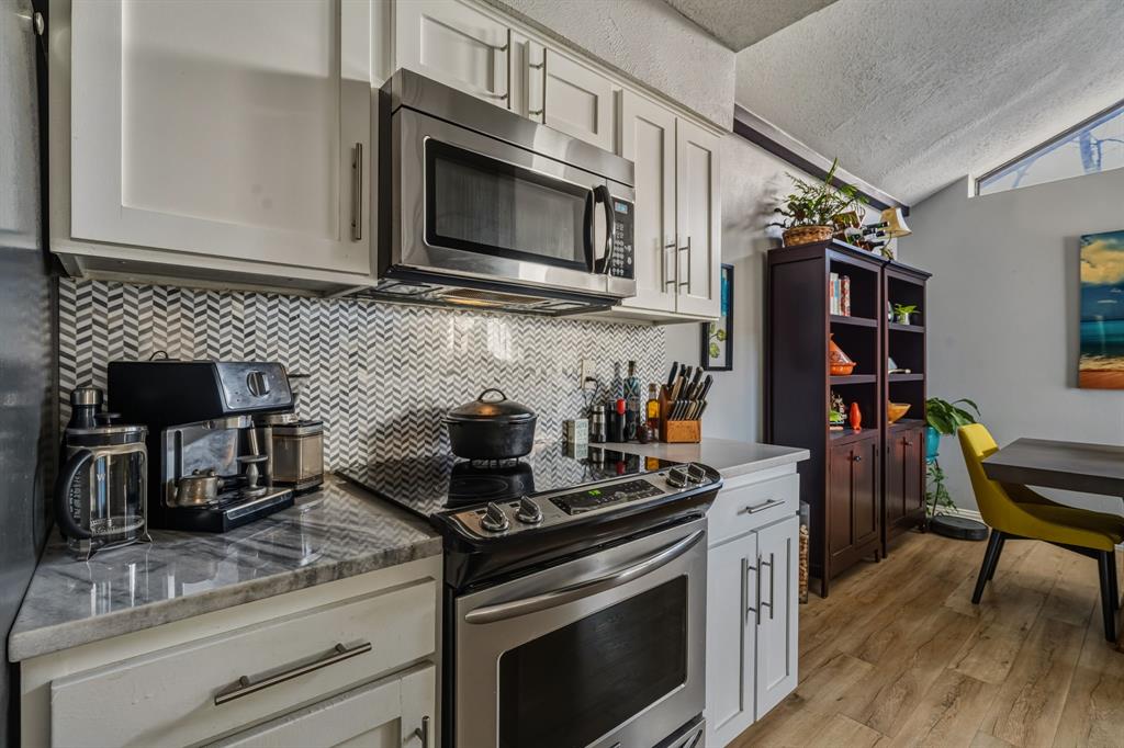 705 Via Miramonte Mesquite, TX 75150 - Photo 24 of 28 a kitchen with stainless steel appliances granite countertop a stove a sink and a microwave
