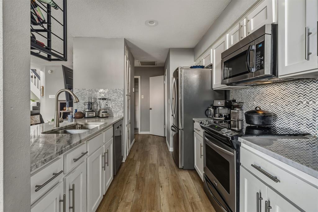 705 Via Miramonte Mesquite, TX 75150 - Photo 4 of 28 a kitchen with stainless steel appliances granite countertop a sink stove and refrigerator