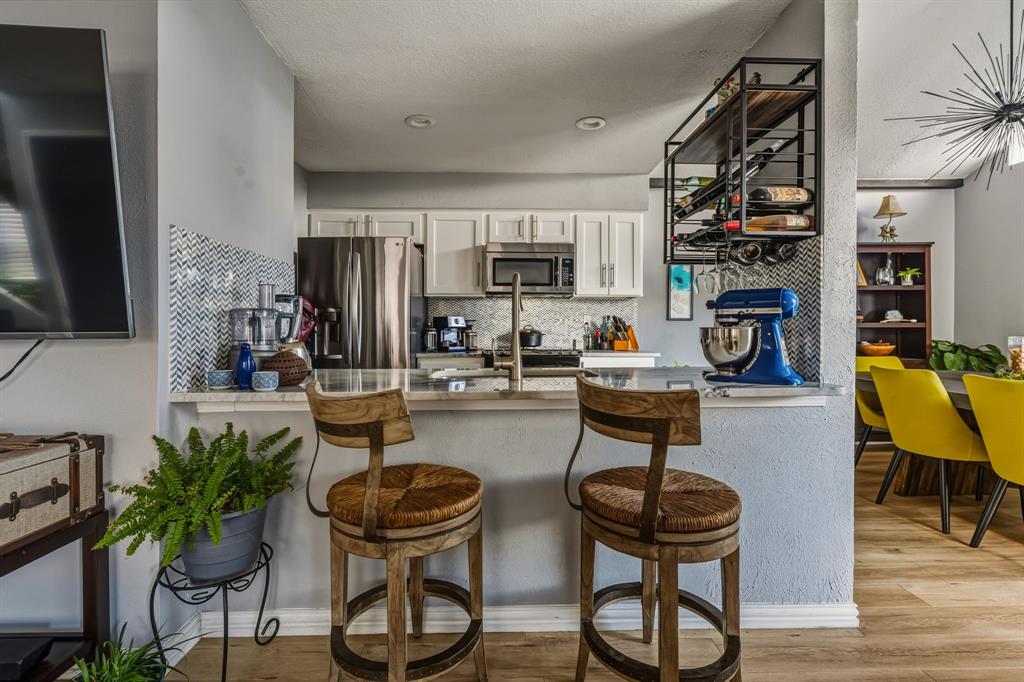 705 Via Miramonte Mesquite, TX 75150 - Photo 9 of 28 a kitchen with stainless steel appliances a table and chairs in it