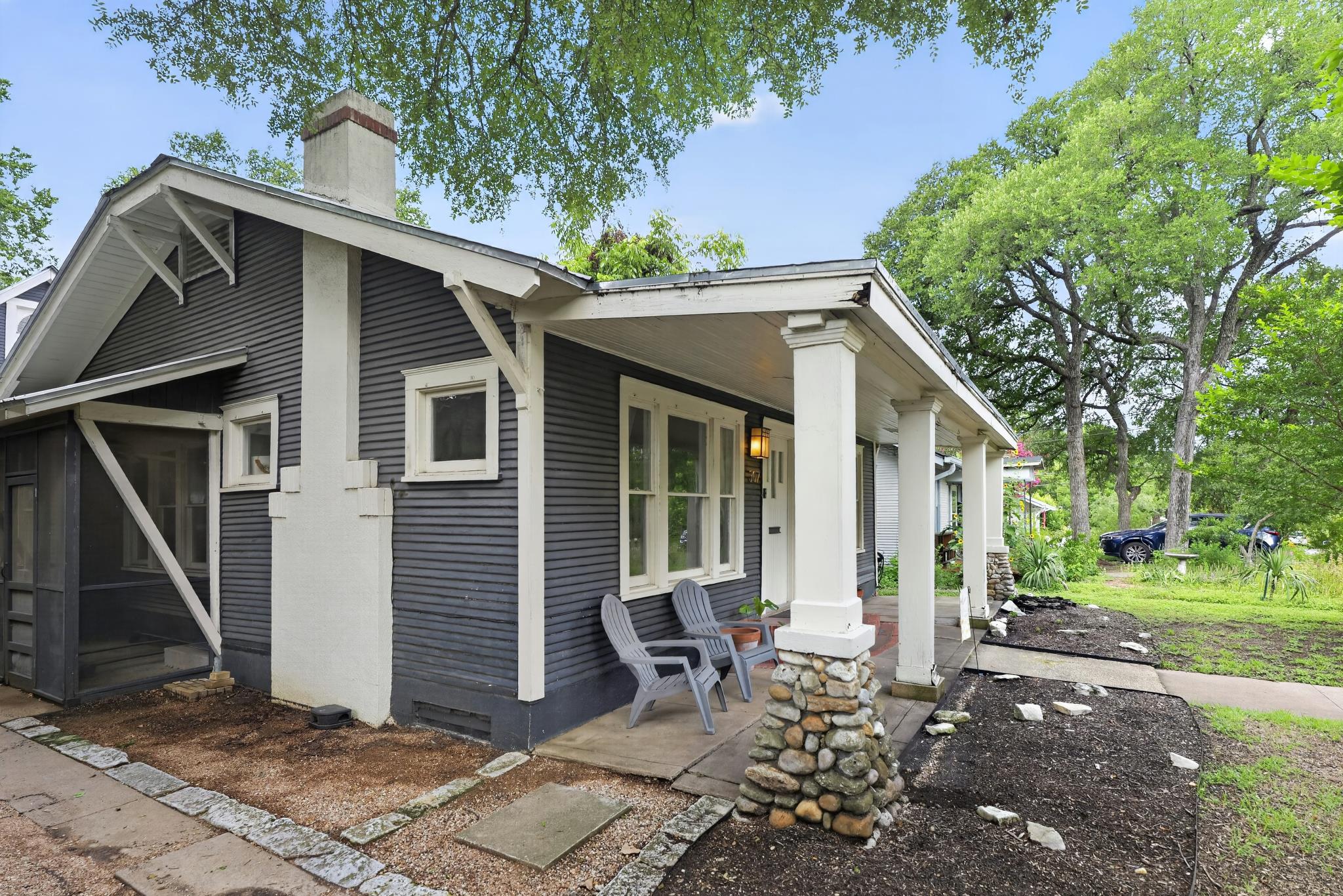 307 East 35th Street, Unit A Austin, TX 78705 - Photo 4 of 40 A charming bungalow with a welcoming covered front porch, featuring stone-clad columns and a classic exterior finish.