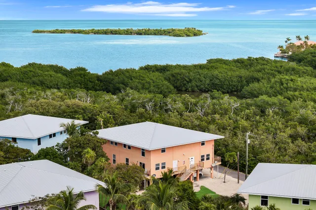 an aerial view of a house with outdoor space and lake view