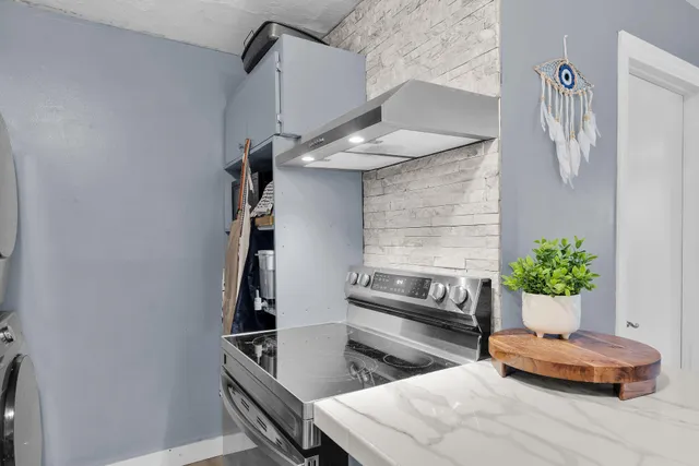 a kitchen with stainless steel appliances kitchen island granite countertop a sink and a refrigerator