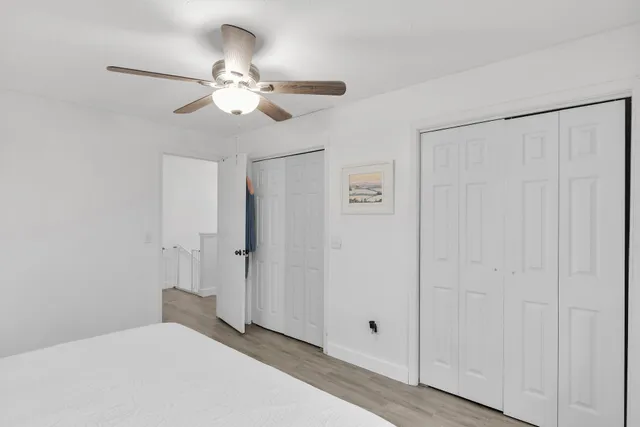 a view of a livingroom with wooden floor windows and a kitchen view
