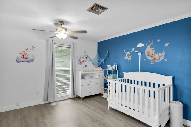 wooden floor with chandelier fan and windows