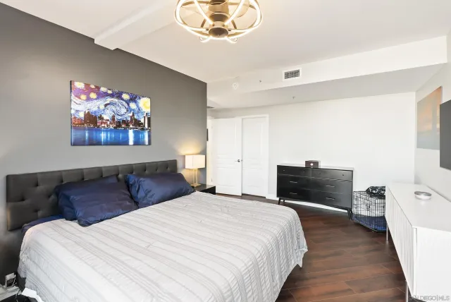 a bedroom with bed and wooden floor