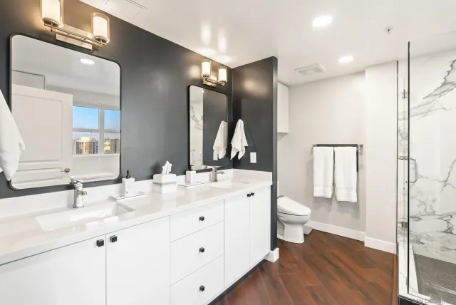 a bathroom with a double vanity sink a toilet and a mirror