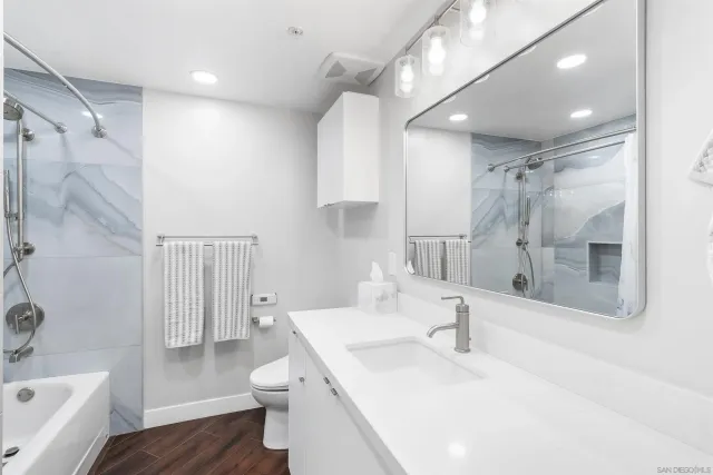 a bathroom with a sink a toilet and shower