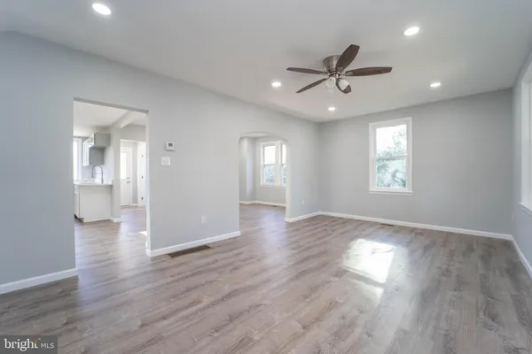 a view of an empty room with window and wooden floor