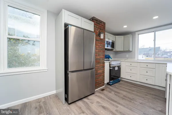 a kitchen with a refrigerator a sink and dishwasher with wooden floor
