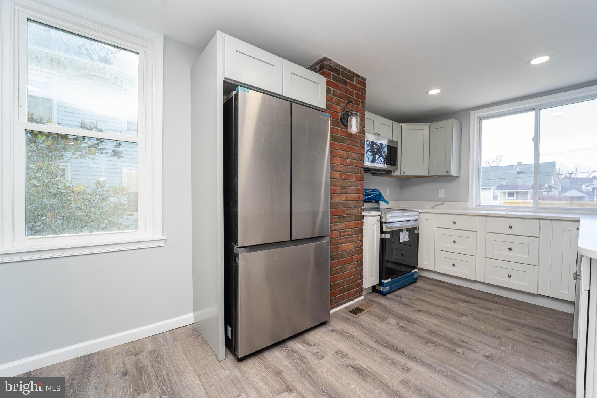 5312 Catalpha Road Baltimore, MD 21214 - Photo 15 of 41 a kitchen with a refrigerator a sink and dishwasher with wooden floor