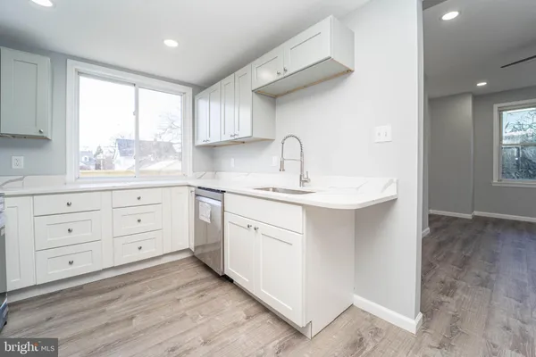 a kitchen with white cabinets and a window
