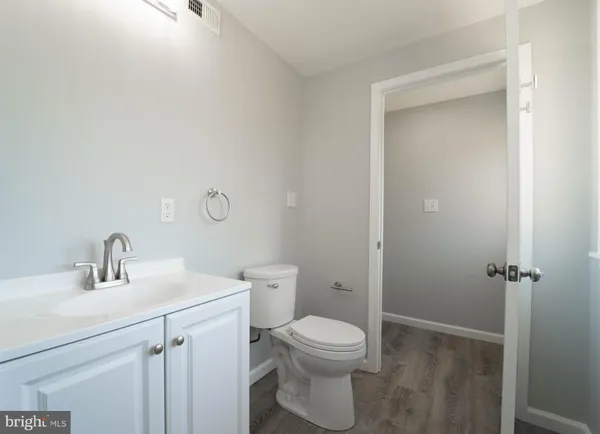 a bathroom with a toilet sink vanity and mirror