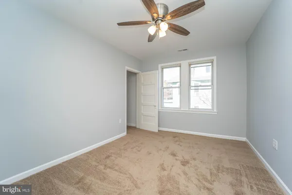 an empty room with windows and fan