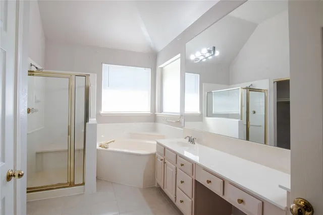 a spacious bathroom with a double vanity sink a mirror and a bathtub