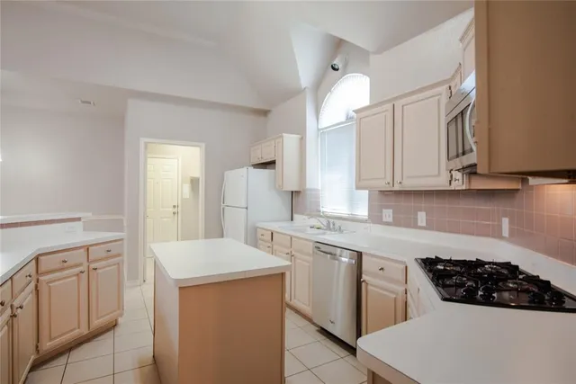 a kitchen with white cabinets and appliances