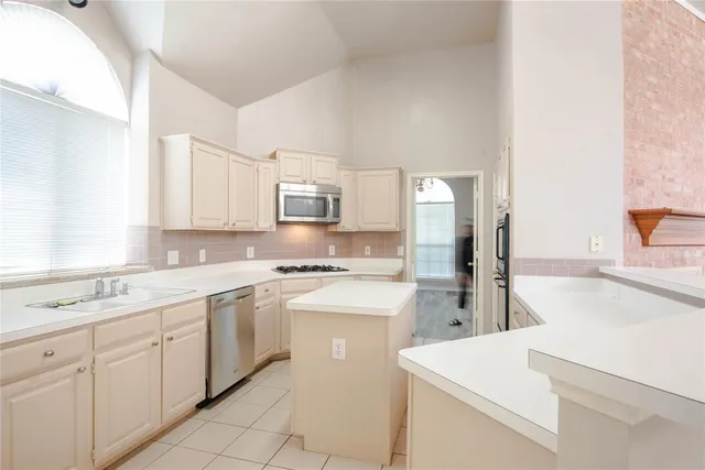 a kitchen with white cabinets and white appliances