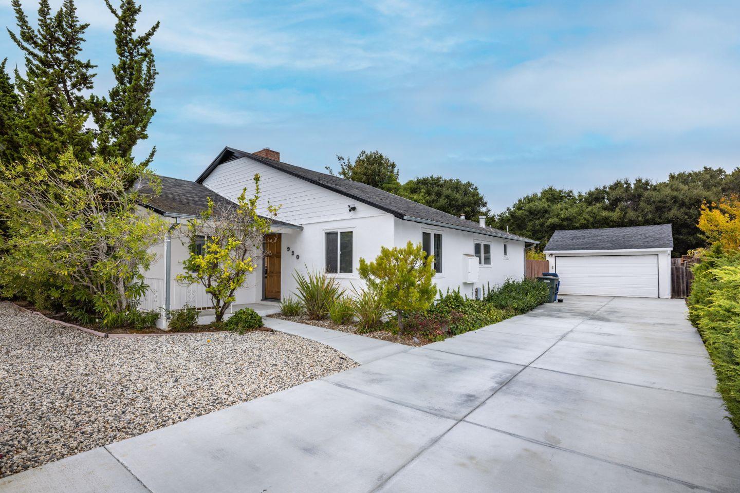 a front view of a house with a yard and potted plants