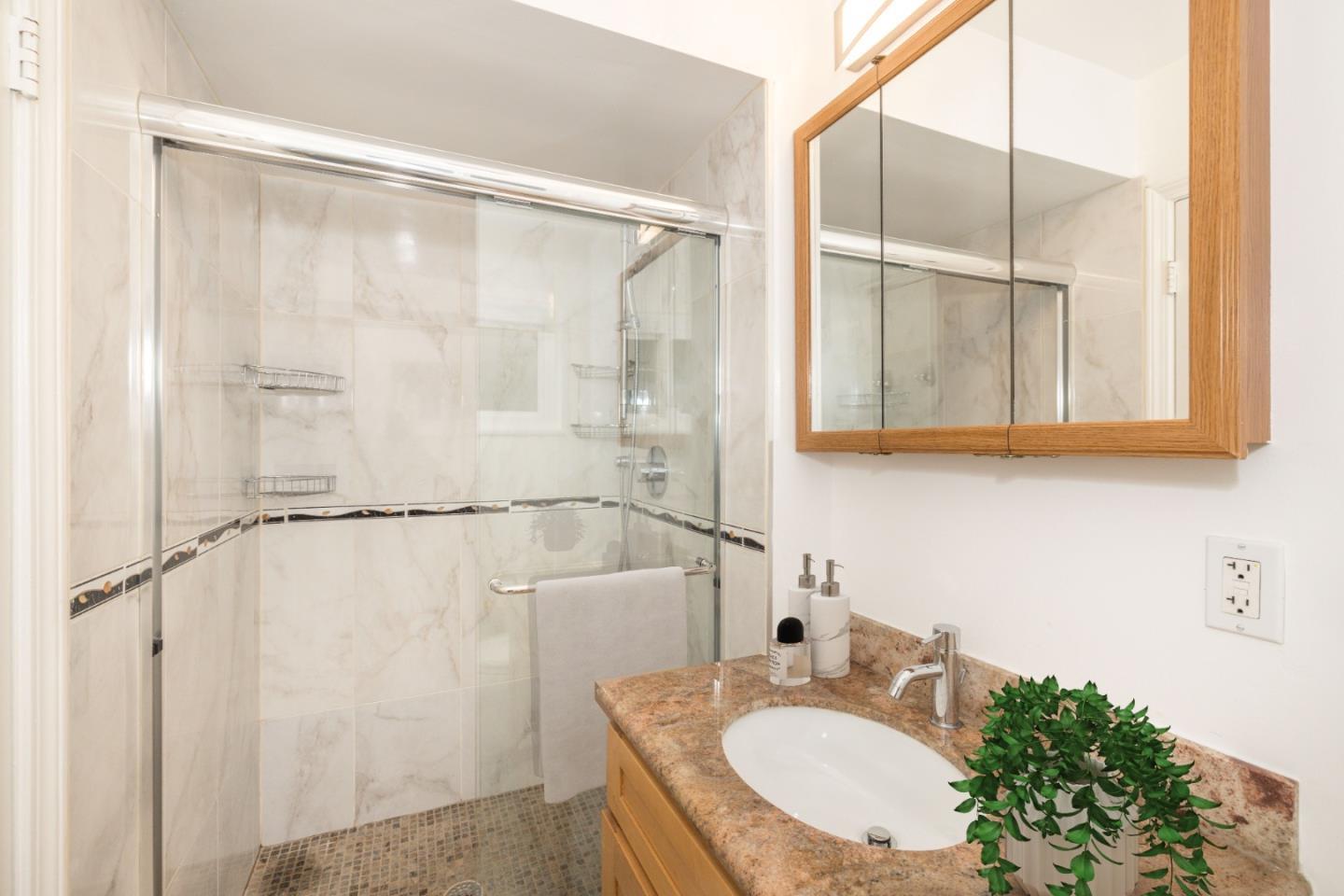 930 Sequoia Avenue Millbrae, CA 94030 - Photo 6 of 10 a bathroom with a granite countertop sink mirror and a shower