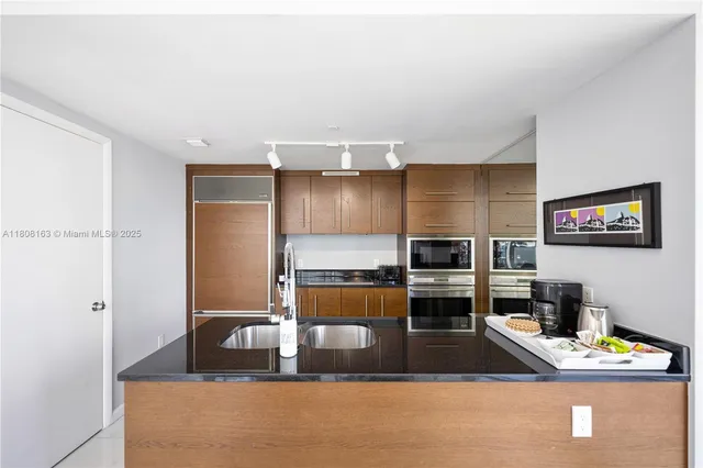 a kitchen with stainless steel appliances a refrigerator and a stove top oven