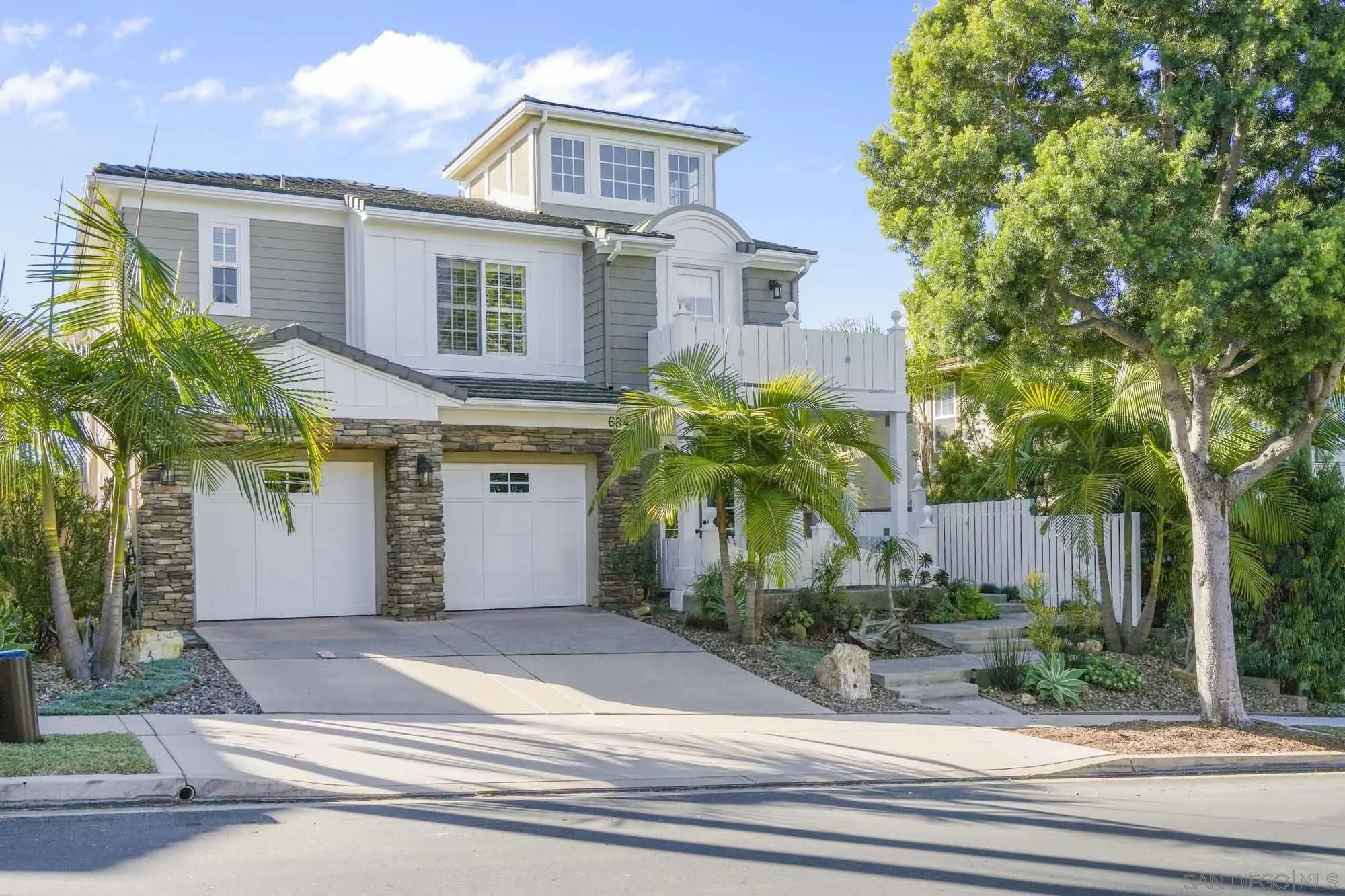 a front view of a house with plants and entryway