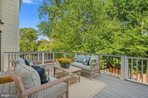 a balcony with wooden floor and outdoor seating