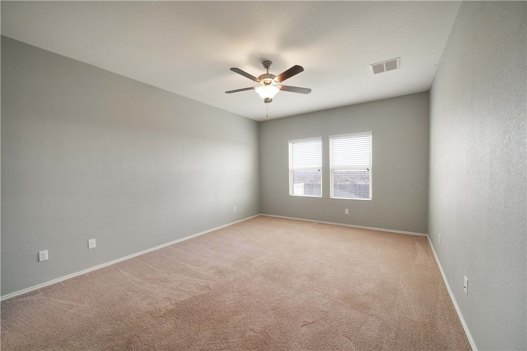 820 Kates Way Hutto, TX 78634 - Photo 13 of 30 an empty room with a window and a ceiling fan