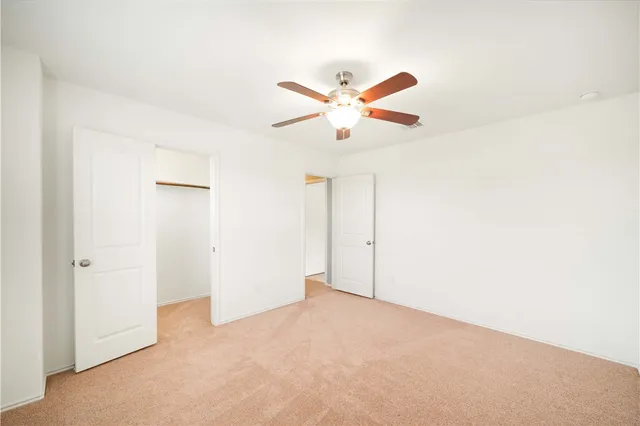 an empty room with closet and fan