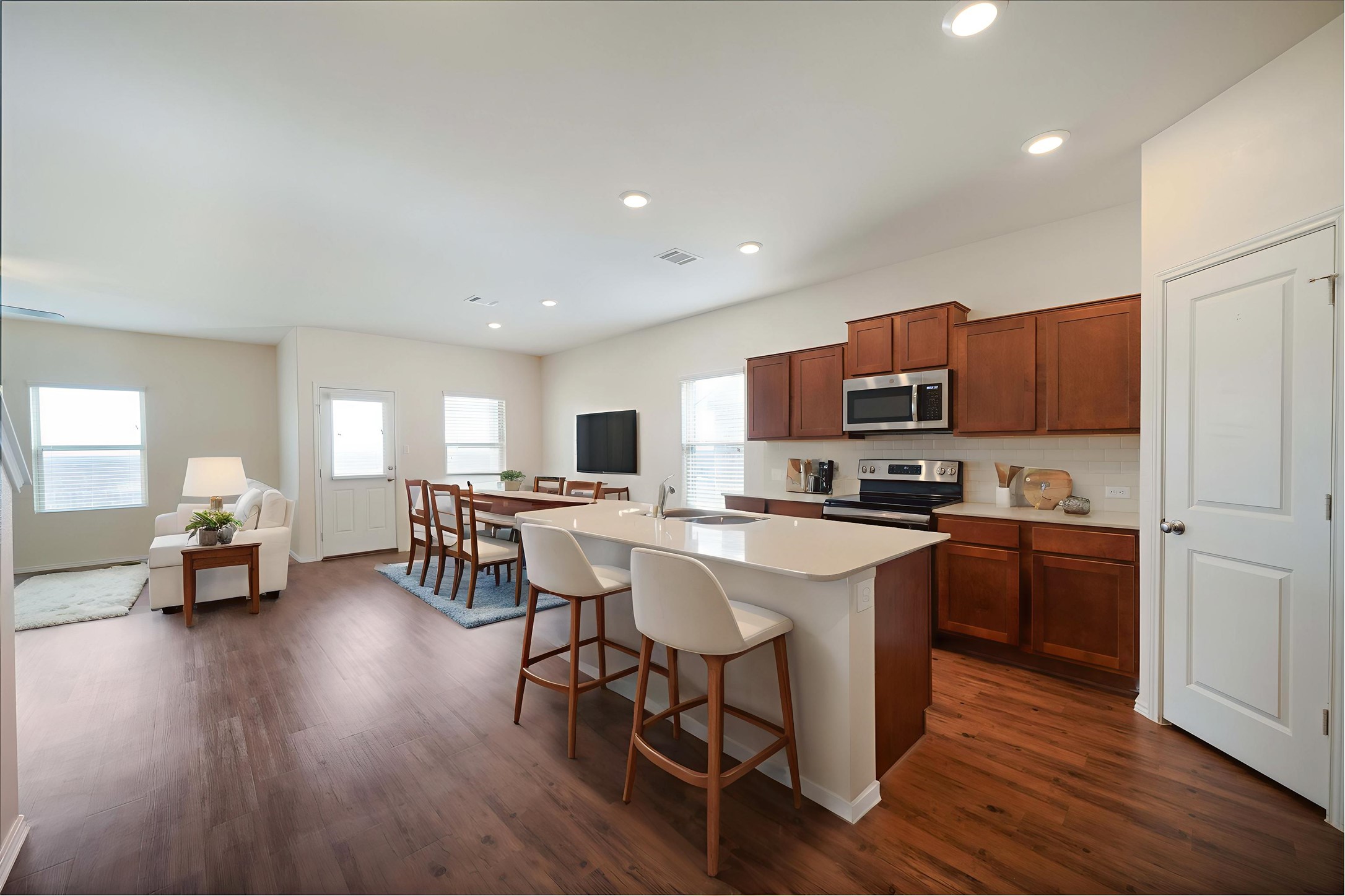820 Kates Way Hutto, TX 78634 - Photo 3 of 33 *Virtually staged* Kitchen featuring stainless steel appliances, a center island with sink, a breakfast bar, wood finish cabinetry, and tasteful backsplash