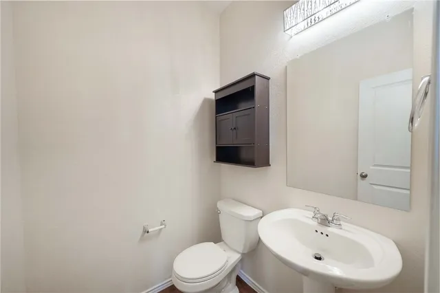 a bathroom with a toilet a sink and mirror