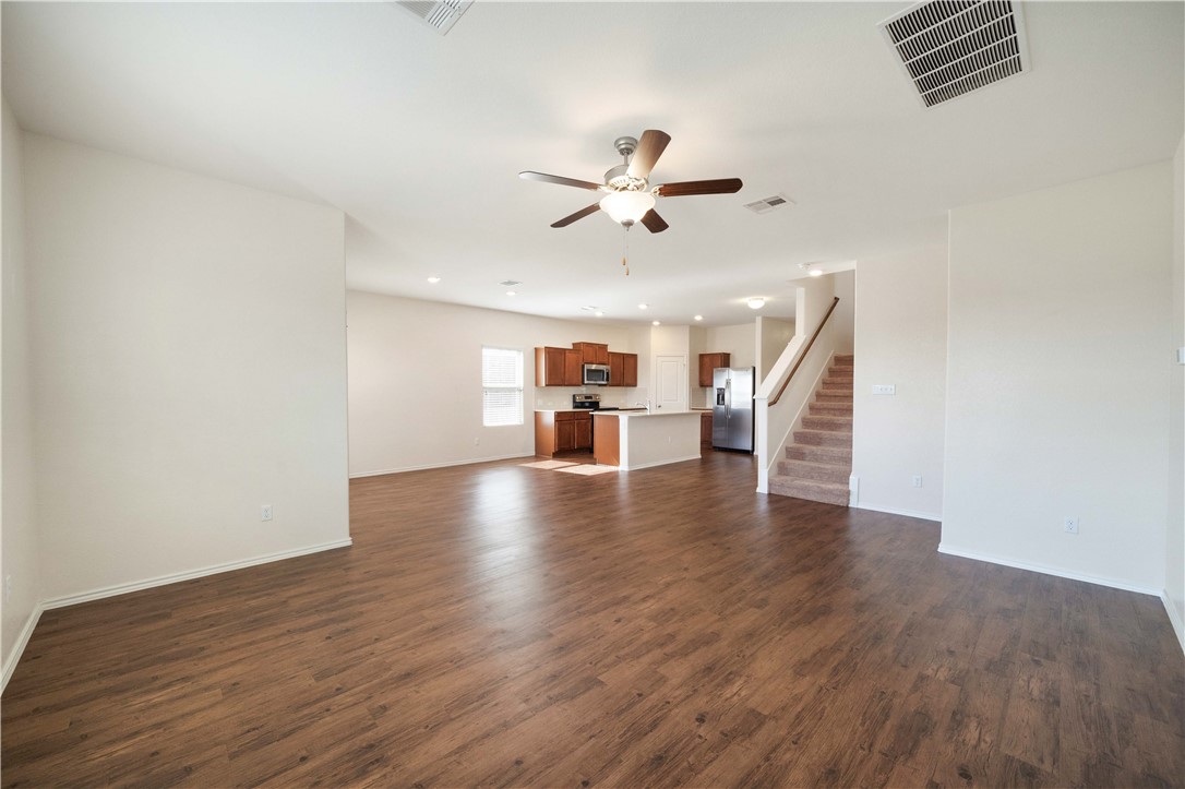 820 Kates Way Hutto, TX 78634 - Photo 10 of 30 a view of a livingroom with wooden floor and a ceiling fan