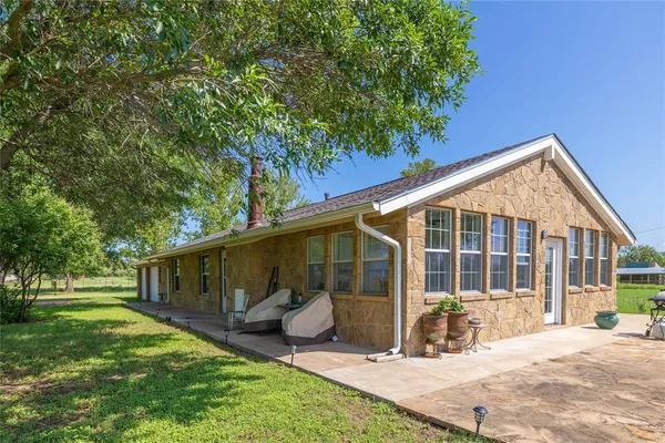 a view of a house with backyard and sitting area