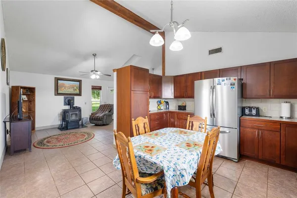 a kitchen with stainless steel appliances kitchen island granite countertop a refrigerator a stove a kitchen island with a dining table and chairs