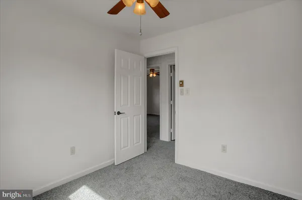 a white toilet sitting next to a small window