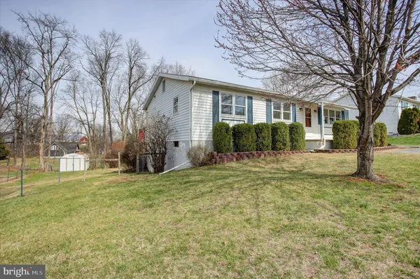 a front view of a house with a yard and trees