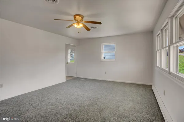 a view of hallway with wooden floor and kitchen space