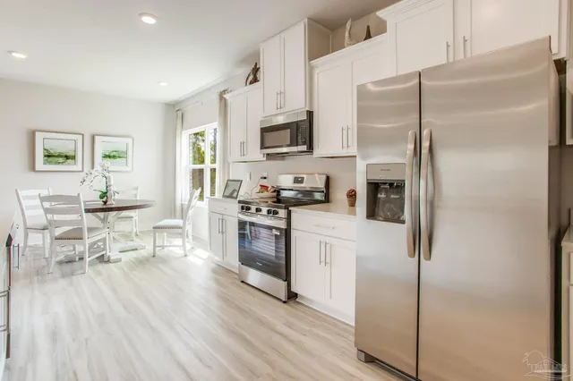 a kitchen with stainless steel appliances a refrigerator and a stove top oven