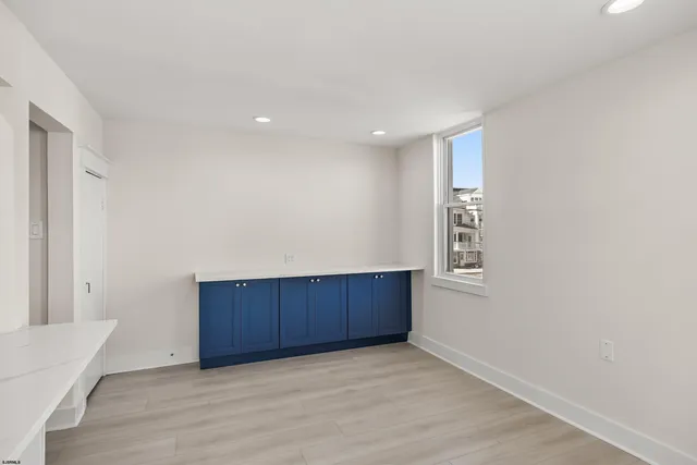 a view of an empty room with wooden floor and a cabinet