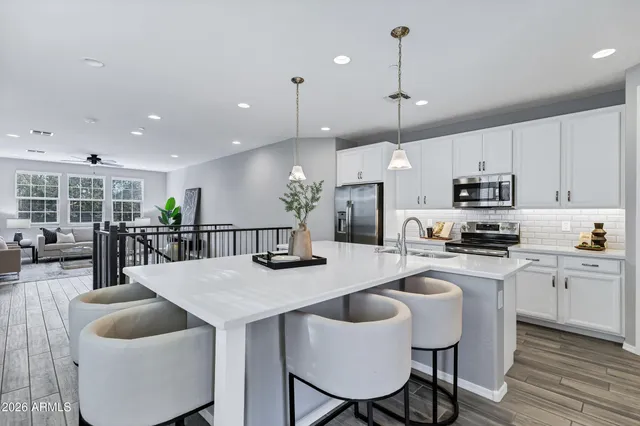 a kitchen with stainless steel appliances granite countertop a kitchen island a stove a table and chairs