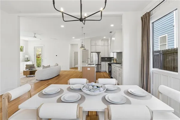 a dining room with furniture and a dining table with kitchen view