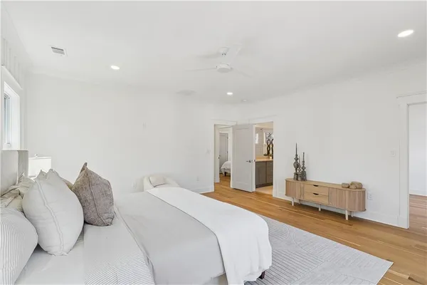 a bedroom with a large bed and a wooden floor