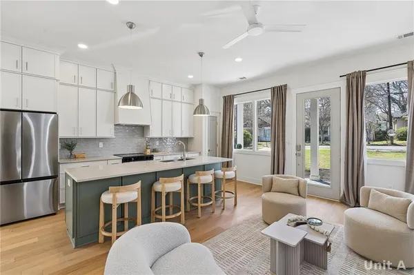 a kitchen with stainless steel appliances a sink a stove a refrigerator and cabinets