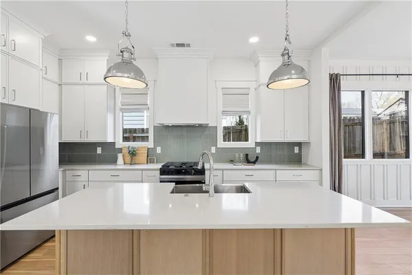 a kitchen with kitchen island a sink appliances and cabinets