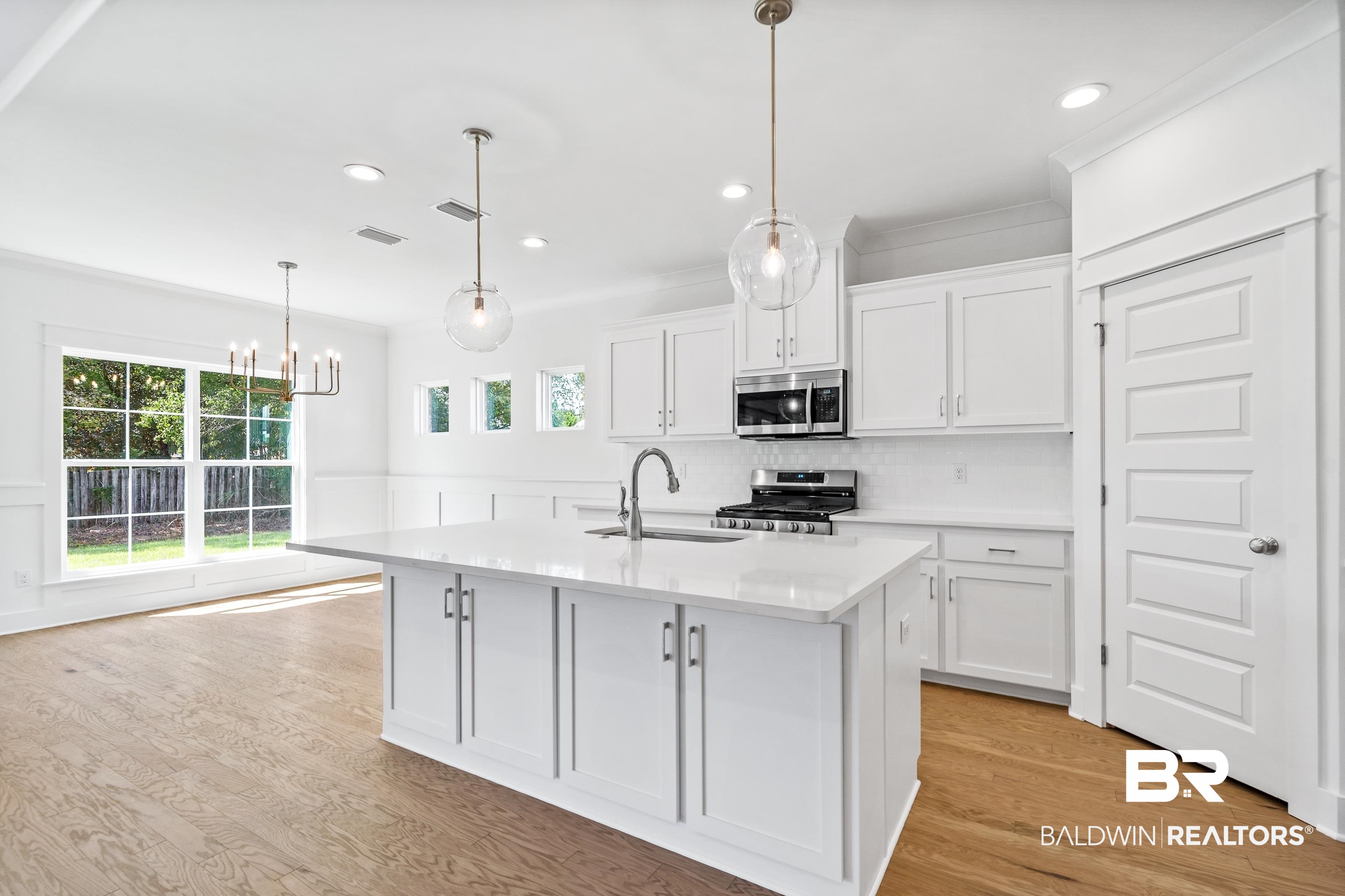 25927 Capra Court Daphne, AL 36526 - Photo 9 of 37 Kitchen featuring stainless steel appliances, sink, white cabinetry, and a healthy amount of sunlight