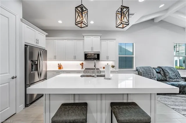 a kitchen with stainless steel appliances a kitchen island a stove a table and chairs in it