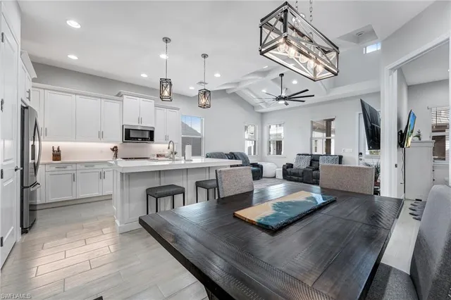 a large white kitchen with lots of counter space and stainless steel appliances
