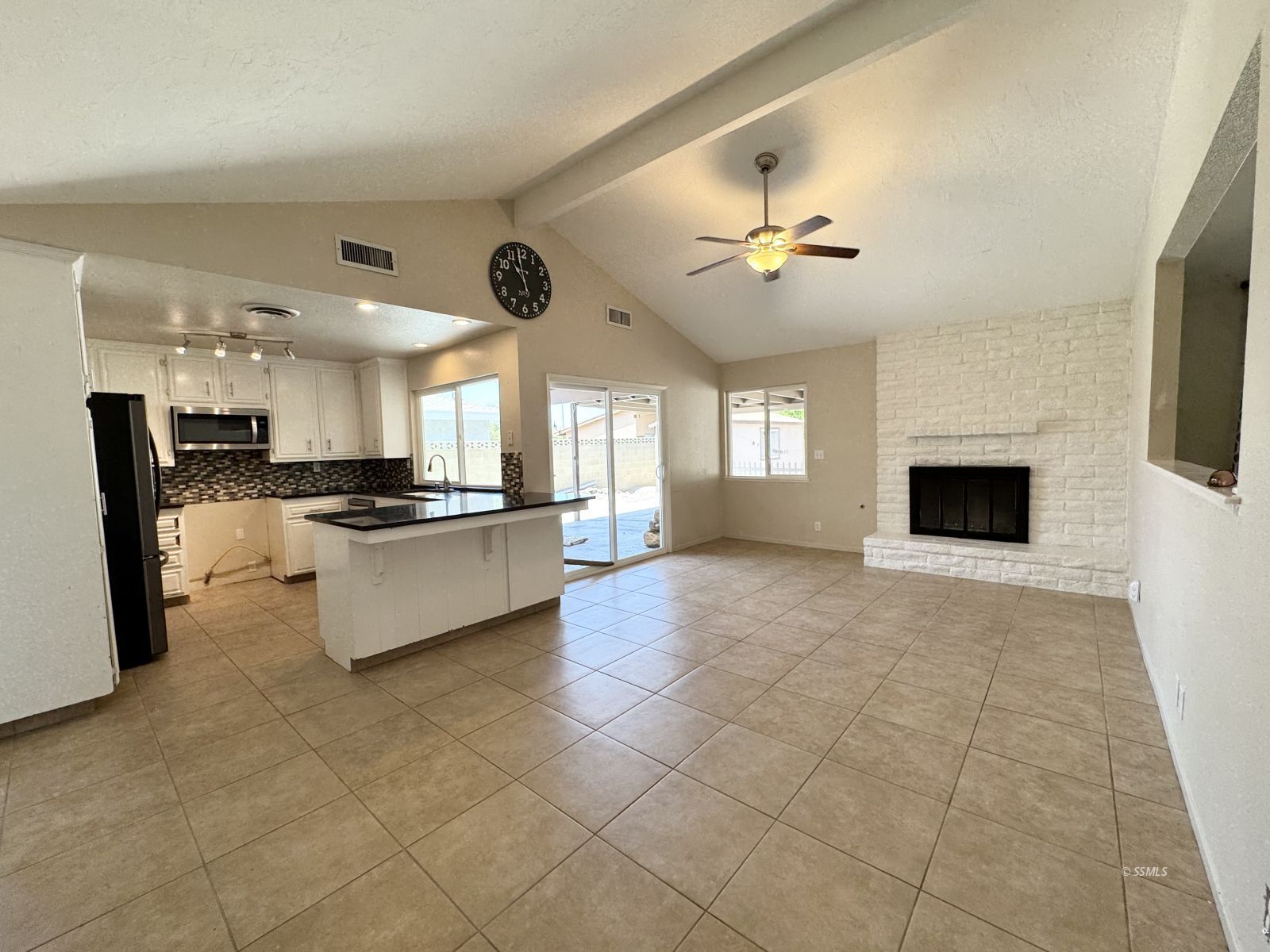 905 North Sierra View Street Ridgecrest, CA 93555 - Photo 9 of 30 a large kitchen with stainless steel appliances granite countertop a stove a sink dishwasher and a refrigerator with wooden floor