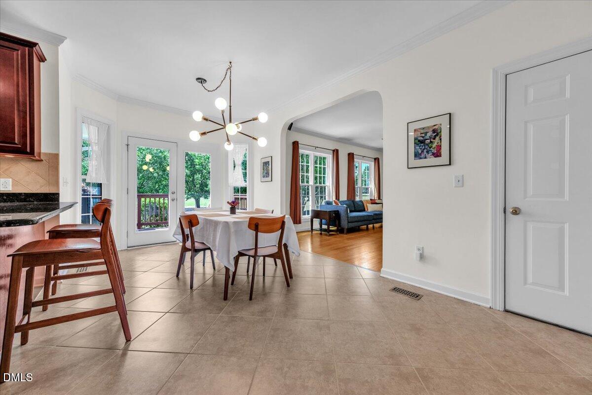 2908 Oak Bridge Drive Raleigh, NC 27610 - Photo 17 of 47 a dining room with furniture a chandelier and wooden floor